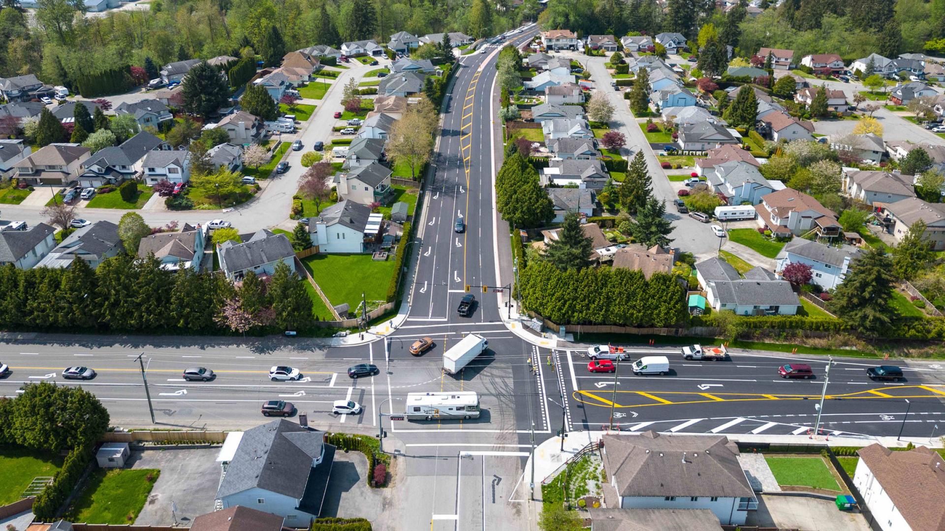 A line of cars travel down 232nd Street and turn onto Abernethy way.