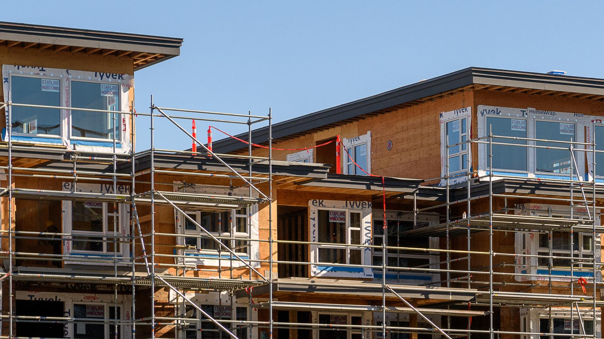 Scaffolding rests against a partially-complete apartment building.