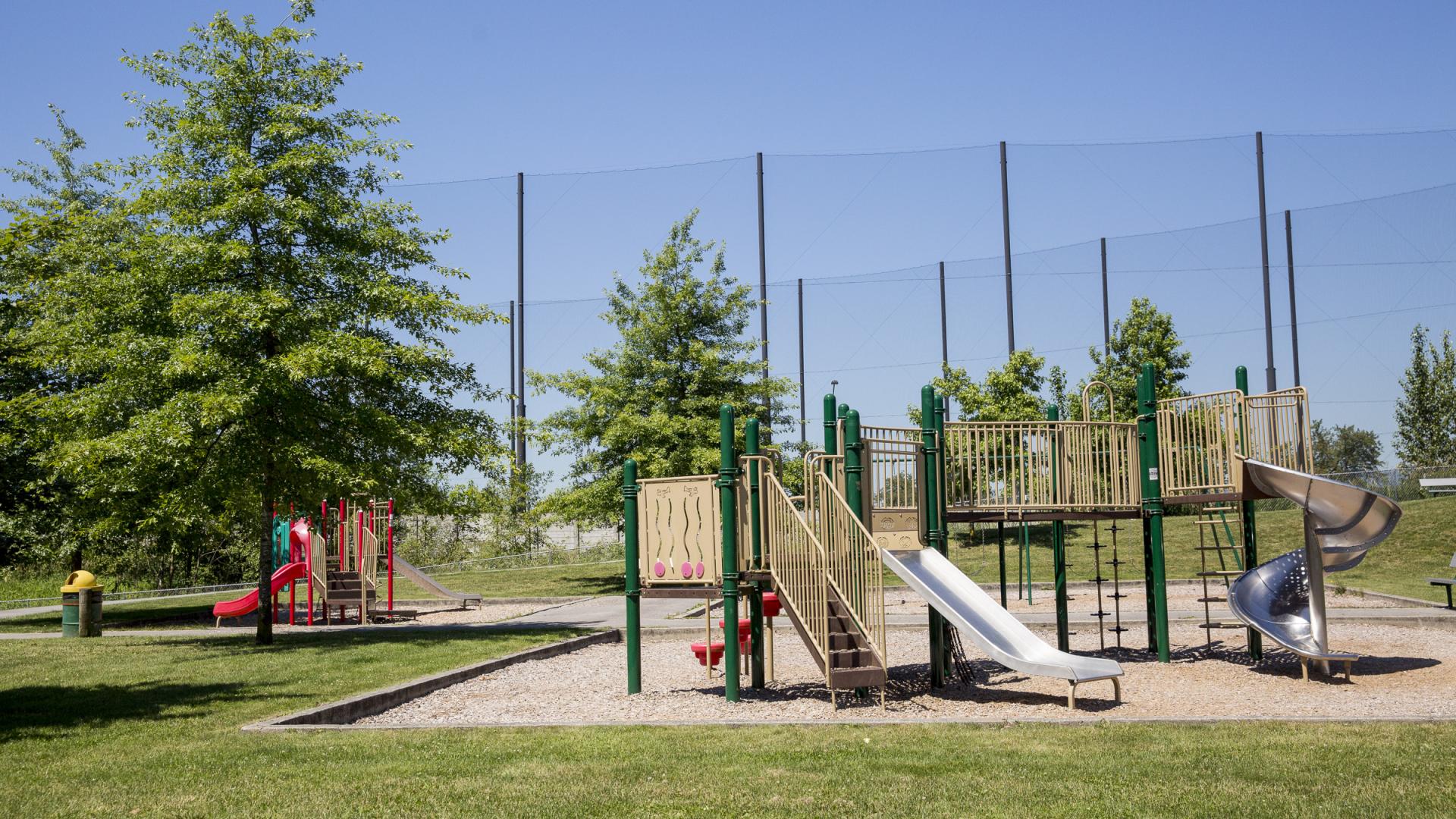 A large playground sits in the middle of Boundary Park, with a smaller one behind it visible past a tree. 