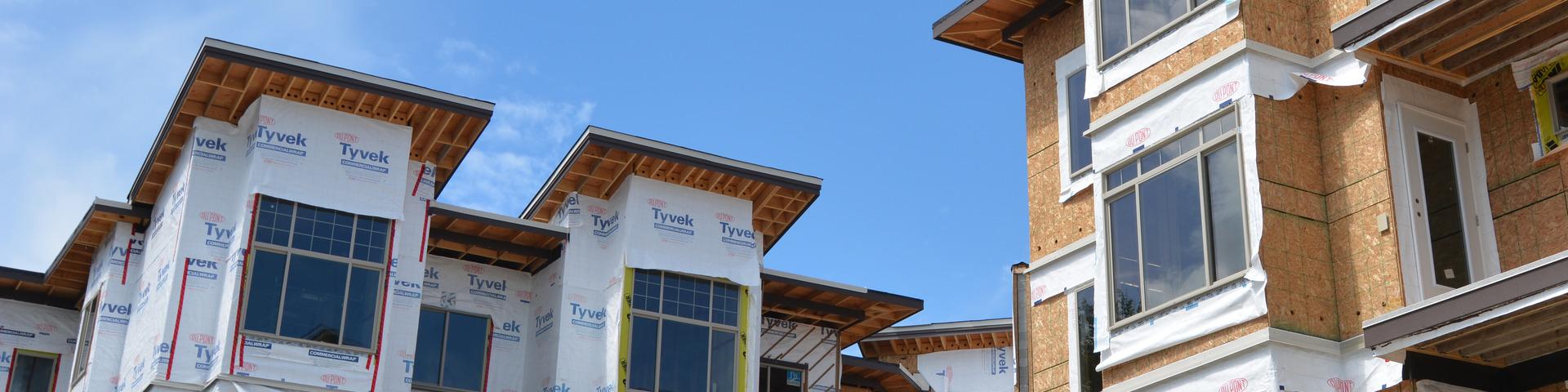 A set of in-progress apartments wait for finishing exterior siding.