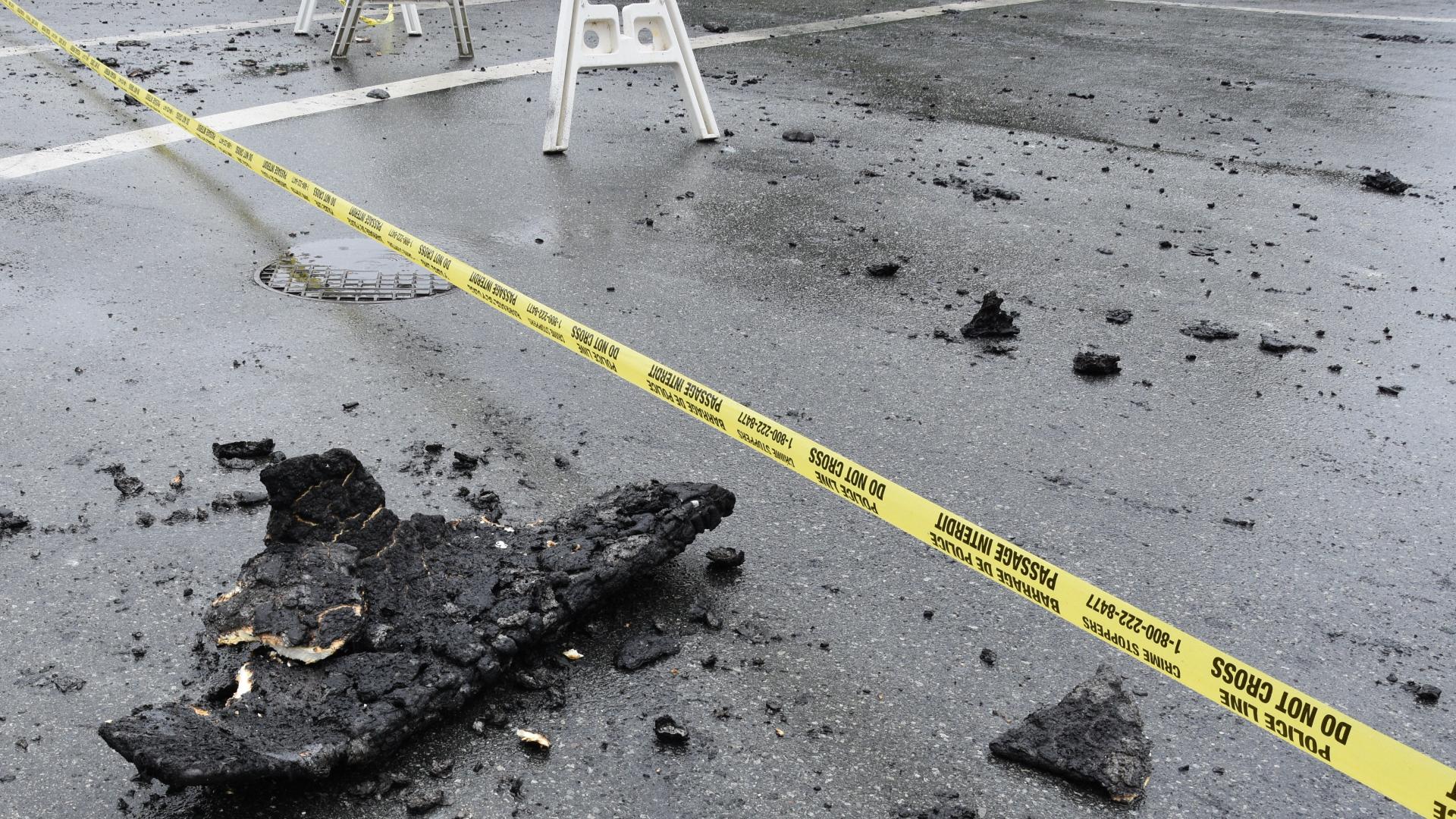 A piece of burned debris sits just behind a line of police tape.