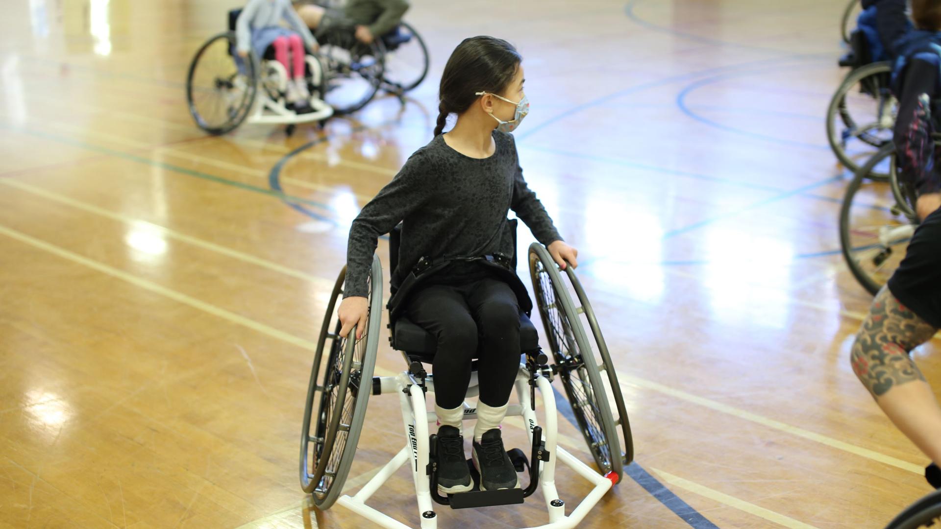 Young girl in a wheelchair on a basketball court