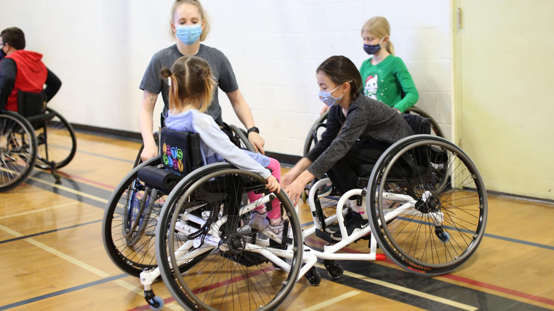 Two young women and two girls playing wheelchair basketball
