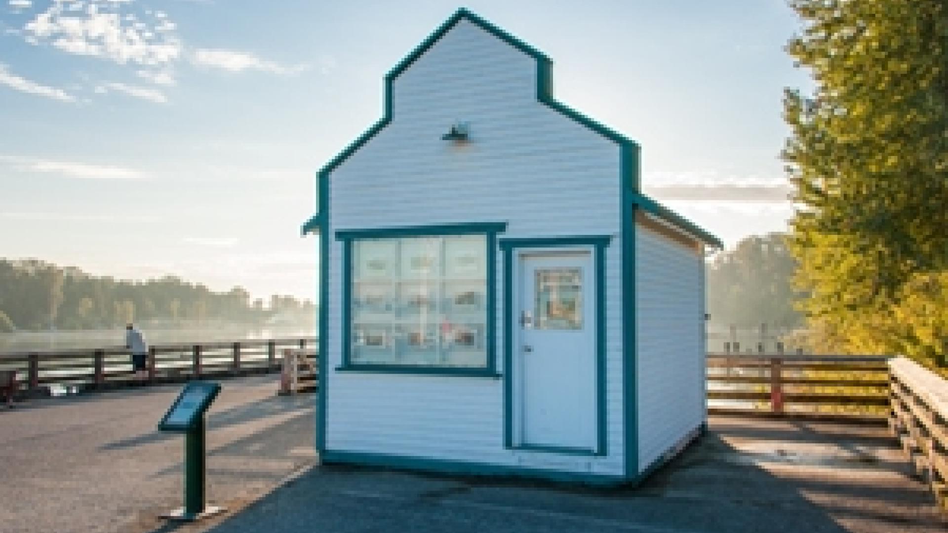 Exterior of Wharfingers Office building. The building is a small white wooden building situated near a wooden pier.