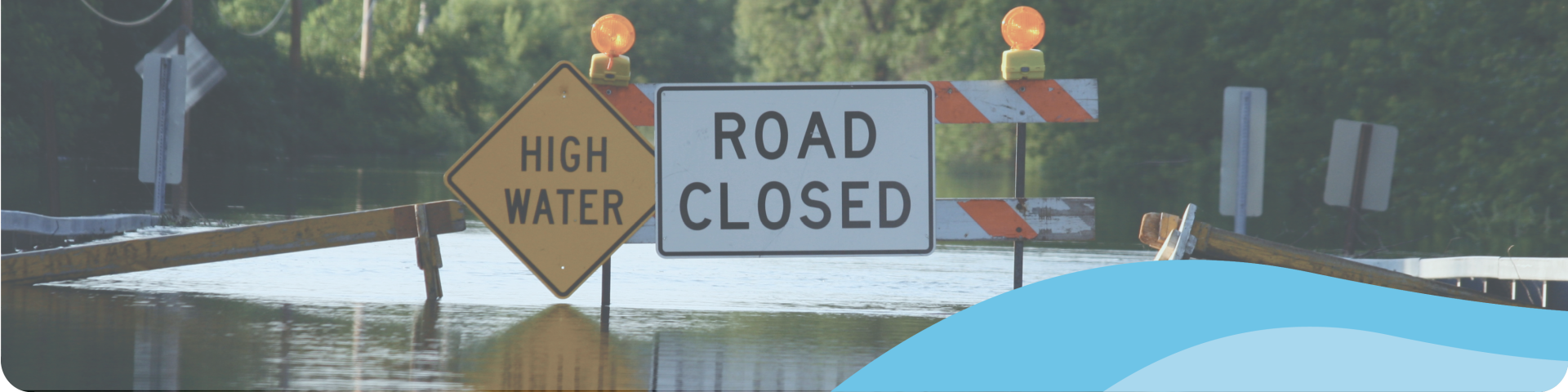 flooded street with a road closed sign